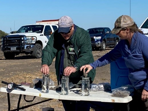 Soil Health Specialist Dennis Brezina conducts soil aggregate stability demonstration with three clear jars on table