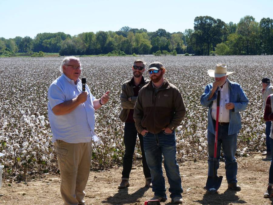 Farmers in cotton field discussing education